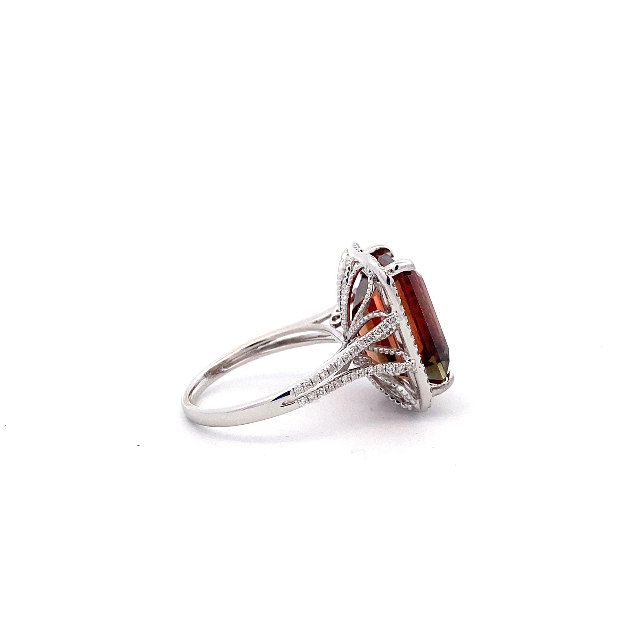 One estate 14 karat white gold ring with a center emerald-cut sunstone accented by 98 diamonds in the halo and the split-shank shoulders of the band
