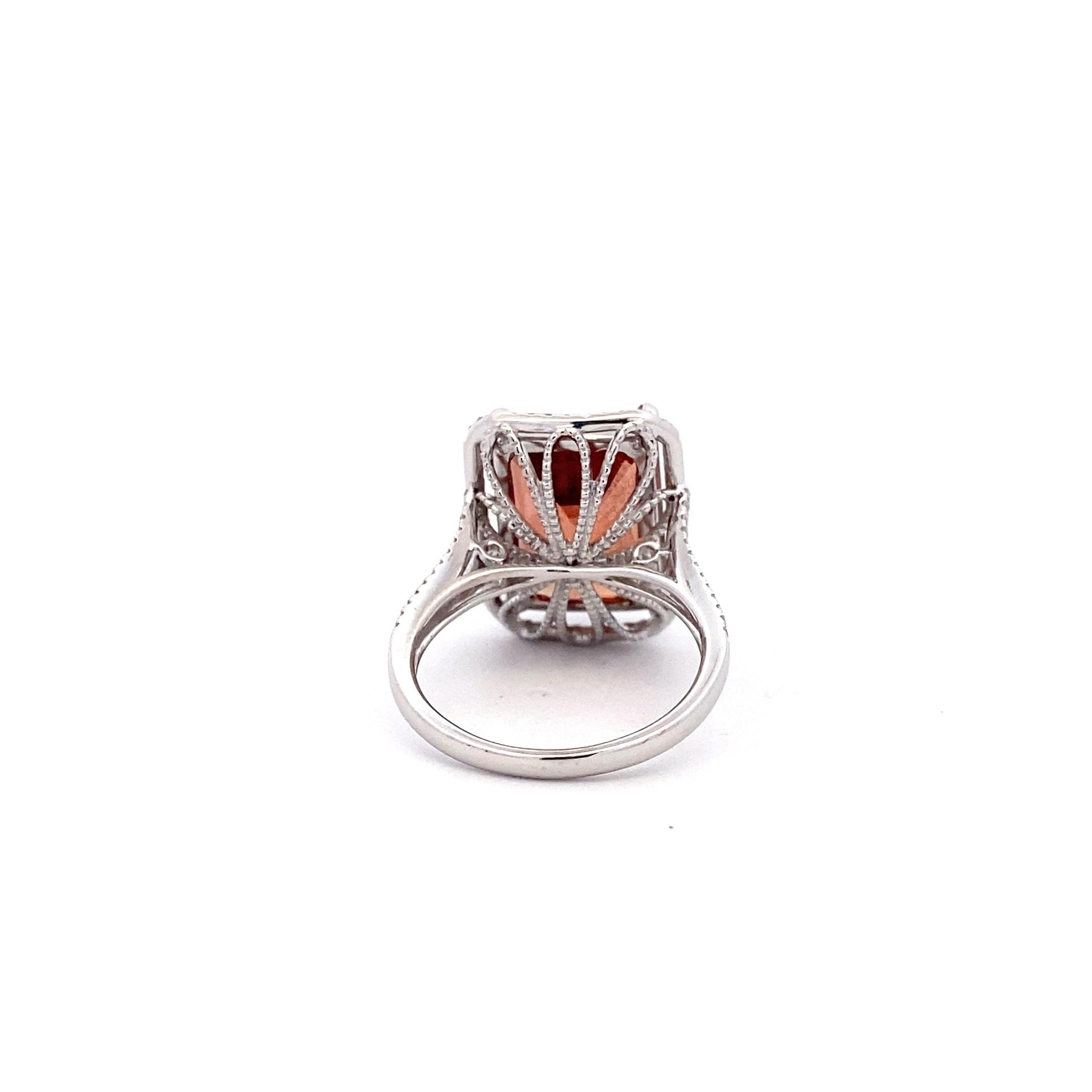 One estate 14 karat white gold ring with a center emerald-cut sunstone accented by 98 diamonds in the halo and the split-shank shoulders of the band