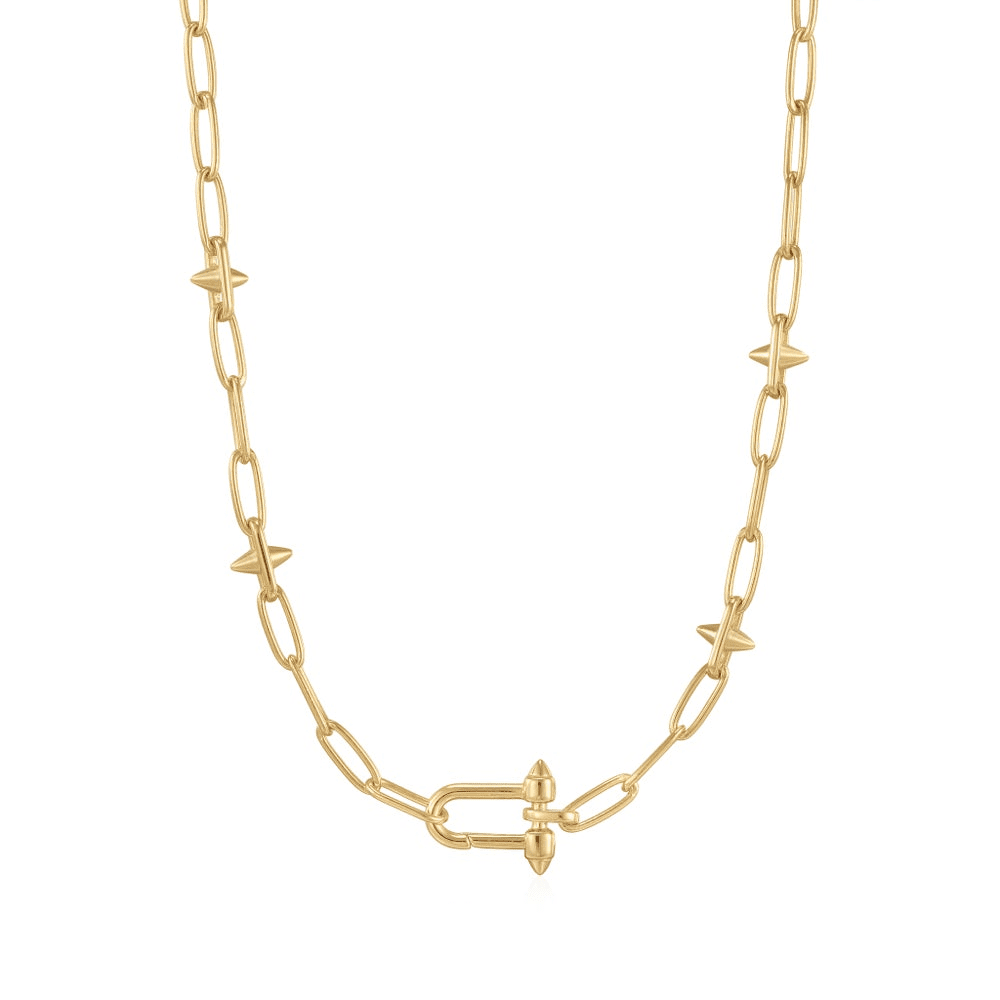 A gold-plated chain necklace alternating between sets of paperclip-style links and studs with an irregular-shaped rectangle in the center of the necklace able to hold charms set against a white background. From the Pop Charms Collection by Ania Haie.