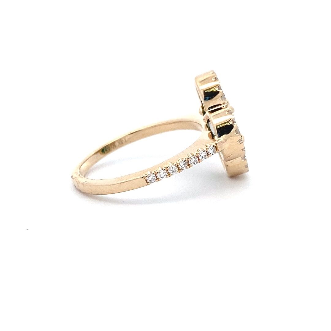 A yellow gold clover ring set with a flat piece of malachite and diamond halo