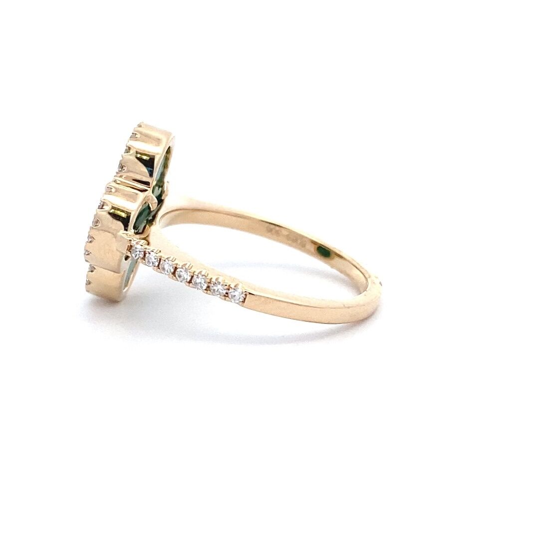 A yellow gold clover ring set with a flat piece of malachite and diamond halo